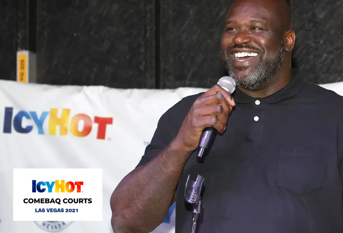 Shaquille O'Neal at the press event on the newly renovated basketball court in Las Vegas, exuding joy with a beaming smile and holding a microphone. The lower-left corner of the image features a label displaying the Icy Hot Comebaq Courts logo, along with the event's year (2021) and location (Las Vegas).